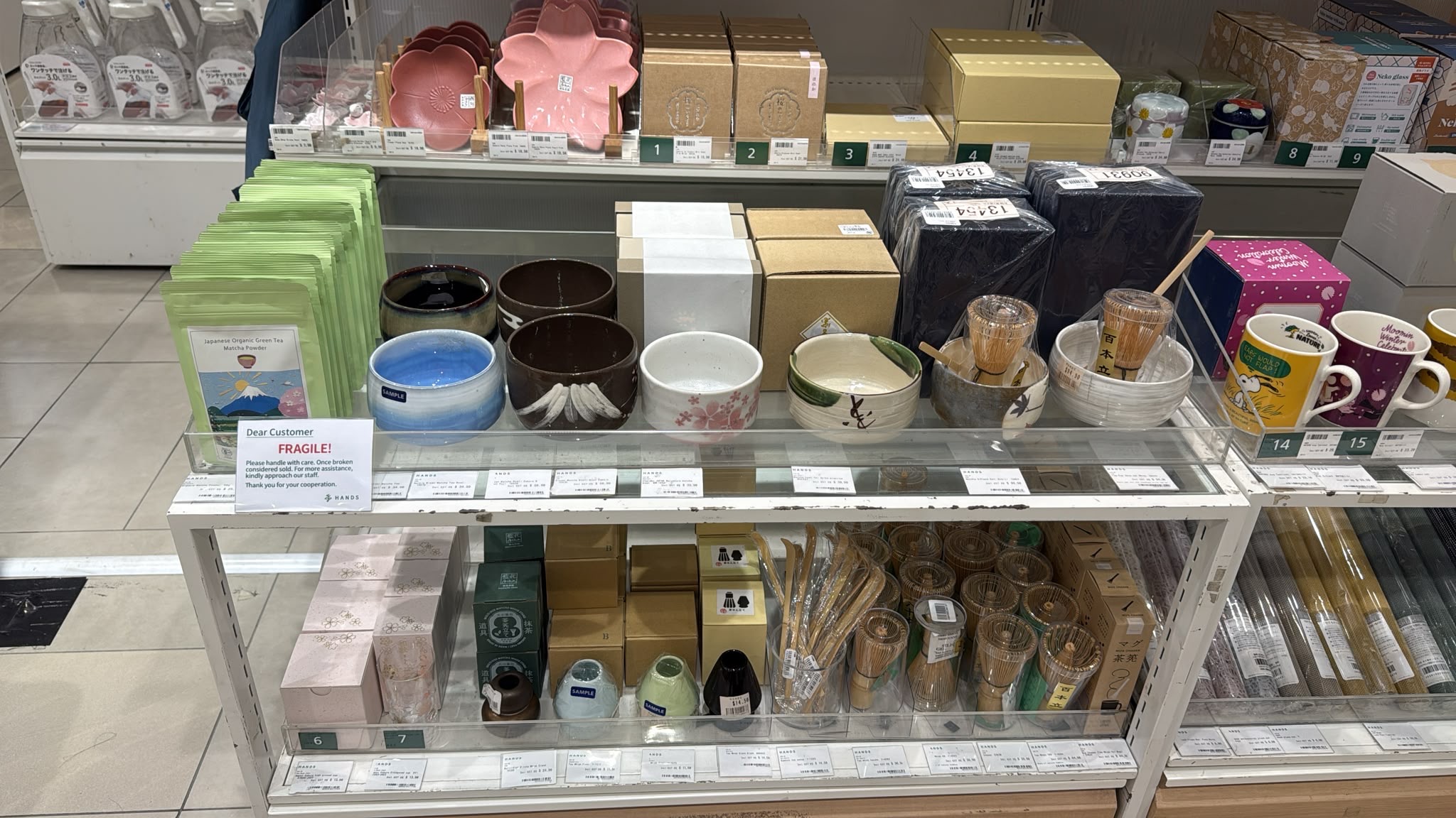 シンガポールSC Storeの日本製品コーナーに並ぶ晴れのち愛の有機抹茶と茶道具、抹茶の点て方を紹介する案内